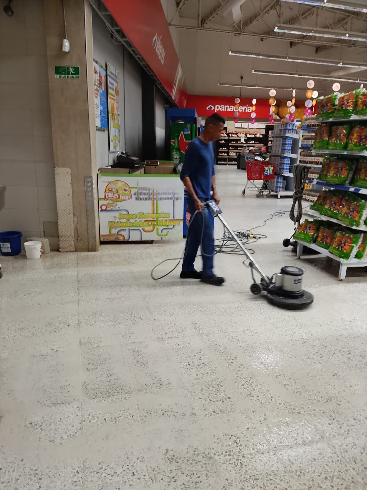 Operario realiza tratamiento de pisos en un espacio comercial